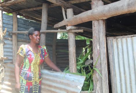 Mukamana poses for a photo besides her kraal ready to feed her cattle