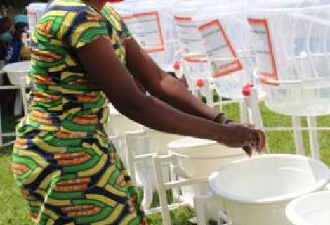 Beneficiary of AAR Handwashing facilities in Nyanza District washing hands